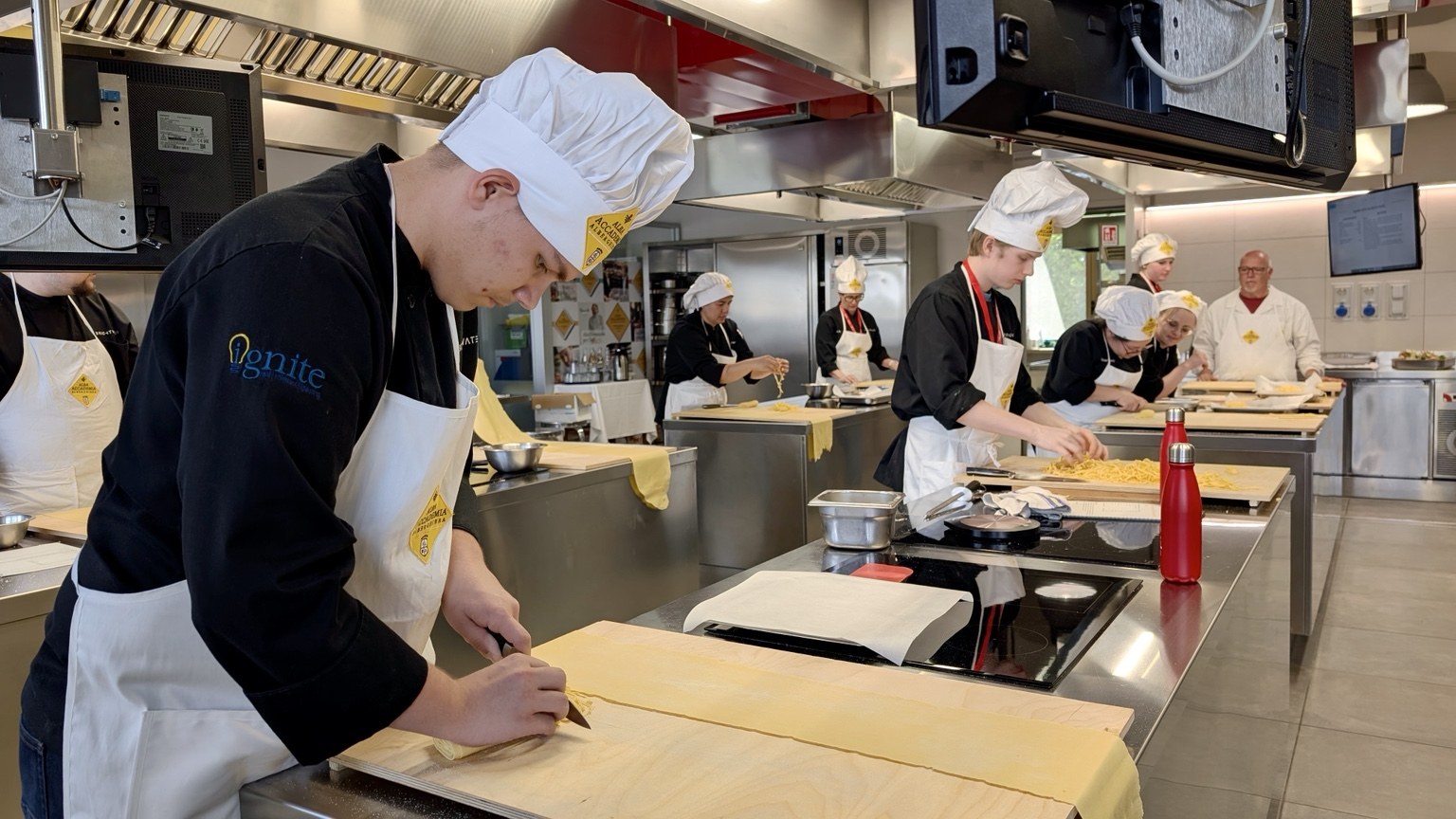 Colby preparing traditional tajarin pasta during culinary study in Italy.