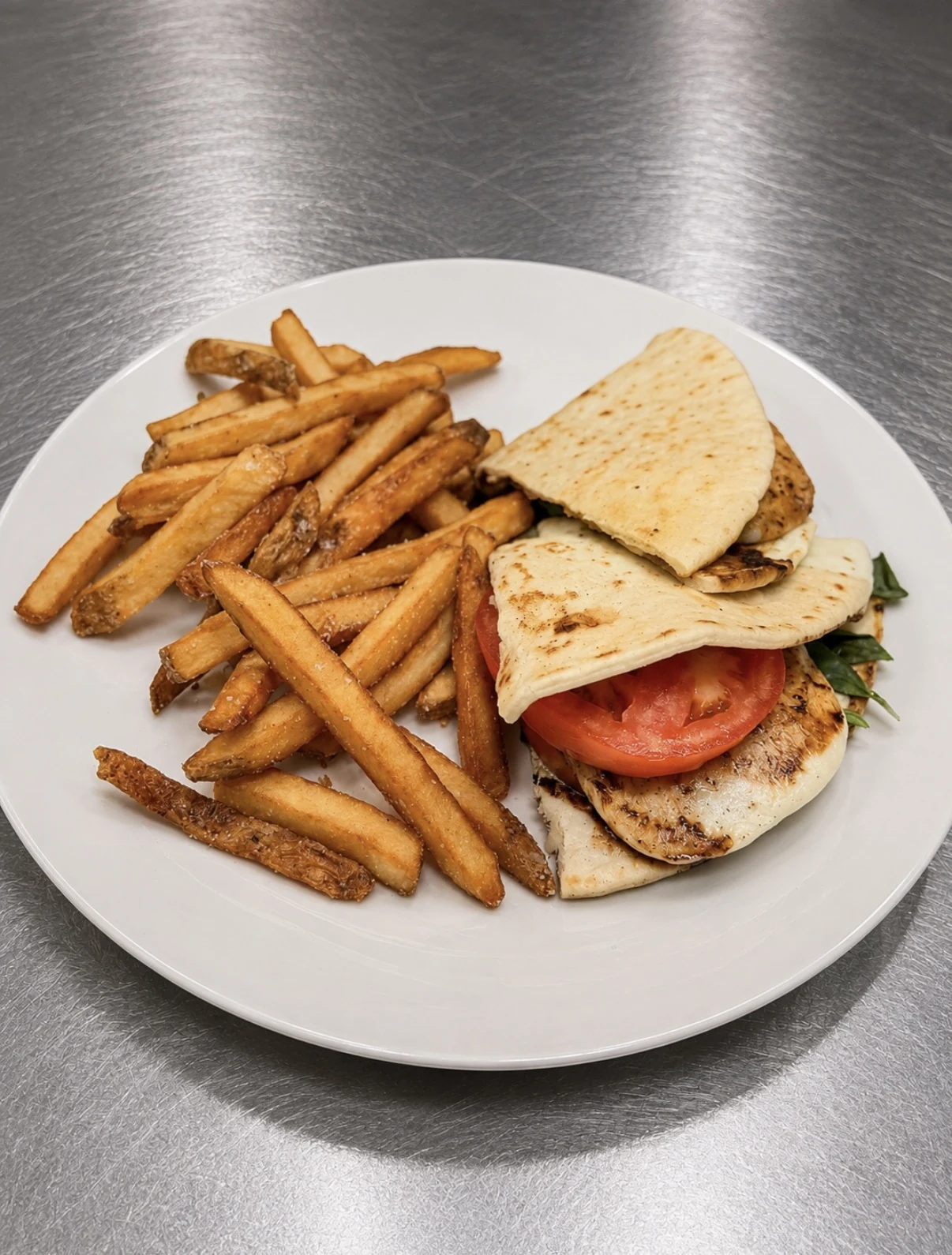 Caprese melt on grilled pita with tomato, mozzarella, basil, and seasoned fries.