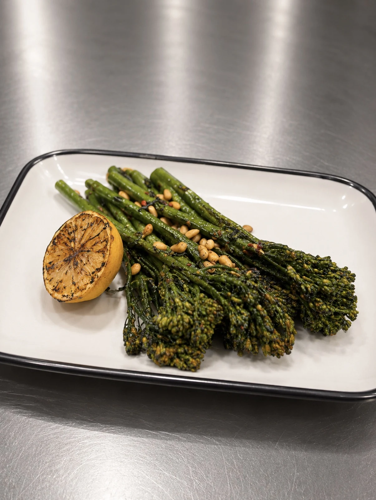 Roasted broccolini with garlic confit, grilled lemon, pine nuts, and chili flakes.